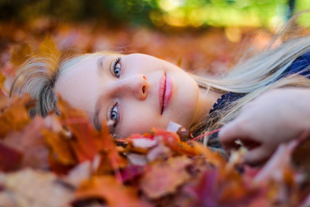 Woman lying on fall leaves