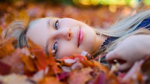 Woman lying on fall leaves